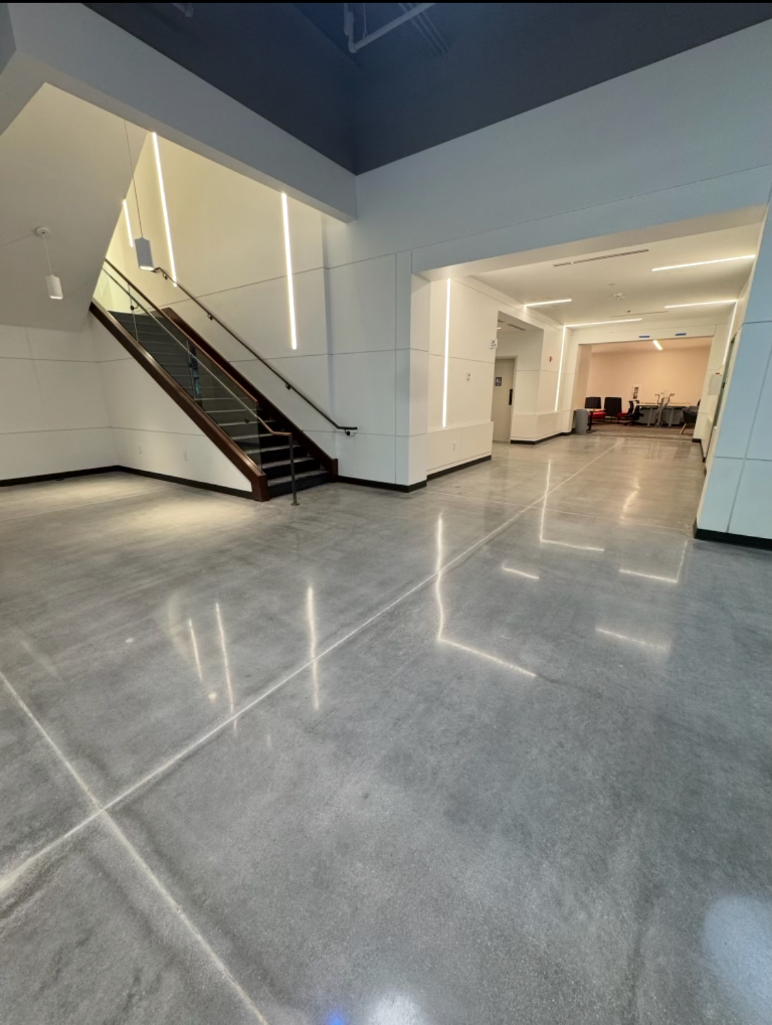 Epoxy & Concrete flooring — Polished concrete lobby floor reflecting the stair rail and lighting — commercial build-out — Gainesville, Buford & Flowery Branch GA
